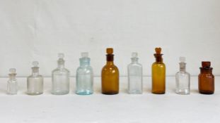 A mixed collection of C.1900 small glass medicine or apothecary bottles with stoppers. H.14cm