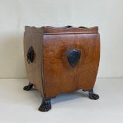 A Georgian mahogany cellarette of square bombe form having a scalloped edge with lion's head