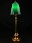 An early 20th century brass and copper table lamp having a ball and spire finial over a conical