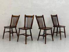 A set of four early 20th century possibly WWI utility scheme elm dining chairs each having a slatted