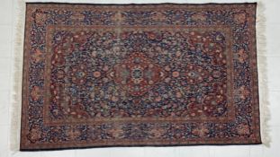 A Persian style Sarouk carpet having a central diamond lozenge medallion surrounded by spandrels and