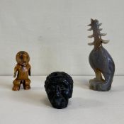 Three figural carvings to include a Chinese jadeite phoenix, a crude black resin head and a
