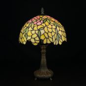 A vintage Art Nouveau Tiffany style table lamp having an acorn cup and cover finial over a domed