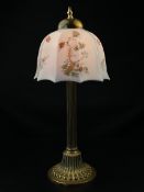 A vintage brass table lamp having a ball and spire finial over a domed and faceted milk-glass
