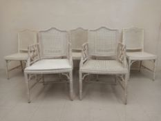 A set of seven vintage faux bamboo dining chairs including two carvers each having a serpentine back