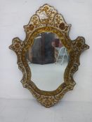 A vintage Venetian verre eglomise style mirror having a shaped plate within a frame comprised of