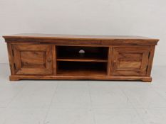 A contemporary mango wood TV cabinet having a dentil moulded cornice over two shelves flanked by two