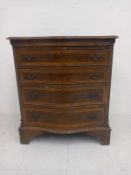 A Georgian style walnut bachelors chest having a burr and cross-banded serpentine top with