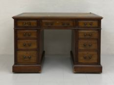 An Edwardian walnut pedestal desk having a tooled and gilt green leather top with a cross-banded and