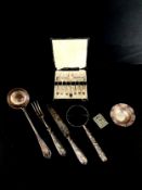 A mixed collection of silver plate to include a boxed set of cake forks, a repousse serving ladle