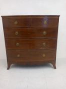 A Georgian mahogany bow-fronted chest of two short over three long cockbeaded drawers raised on