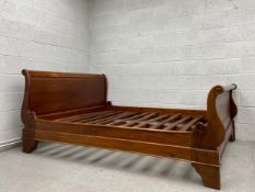 A contemporary mahogany double sized sleigh style bedstead. Fits a 5ft mattress.