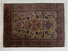 A Persian style Sarouk rug having a central diamond lozenge medallion surrounded by spandrels and