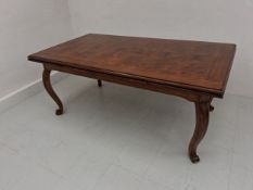 A contemporary mango wood extending dining table having a rectangular thumb moulded burr top with