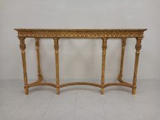A Louis XVI style giltwood console table having a repeating carved flowerhead medallion pattern