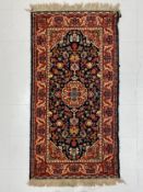 A wool Sarouk style rug having a central flowerhead medallion surrounded by foliate decoration