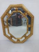 A French Regency style carved giltwood wall mirror having an octagonal plate in a thin gilt surround