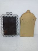 A vintage wall mirror having a rectangular plate in a scrolling wrought iron surround along with