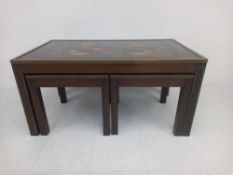 A 1970s nest of tables to include a rectangular brass bound mahogany coffee table with a lacquered