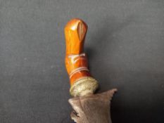 A 20th century Indonesian ceremonial Kris dagger with a carved hardwood handle and sheath and a