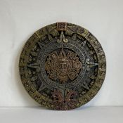 A vintage metal replica of The Sun Stone or Aztec calendar having a central face depicting the sun
