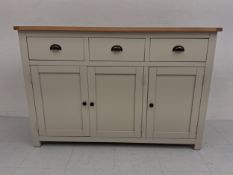 A contemporary painted sideboard in the 19th century style having a rectangular plank top over an