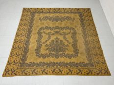 A large needlework tapestry having a central floral motif in a scrolling flowerhead cartouche draped