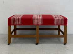 A contemporary ottoman or window seat having a rectangular striped calico upholstered stuff-over