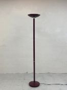 A contemporary lacquered metal floor standing lamp having a splayed uplighter shade on a narrow stem