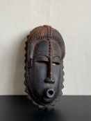 A West African carved hardwood ceremonial Mblo dance mask from the Baule tribespeople of the Ivory