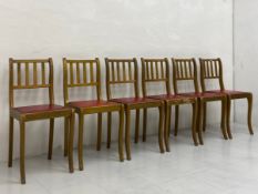A set of six mid century gilt dining chairs each having a shaped and slatted back over a faux