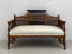 A 20th century Syrian oak Mashrabiya settee or sofa having a moulded cornice with an ebonised plaque