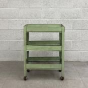 An early to mid 20th century industrial metal trolley in a painted pollard green finish having a