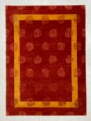 A vintage carpet having an all-over stylised rosehead pattern over a mottled red ground with and