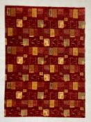 A vintage wool carpet decorated all-over with irregular square panels in shades of yellows,
