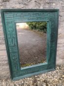 A wall mirror having a rectangular plate within a wide faux patinated bronze frame carved with a