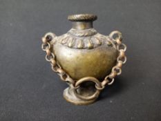 A 19th century Nepalese Newar or bronze inkwell in the form of a Kalashah or ritual vase suspended