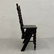 A C.1900 oak metamorphic library chair having a turned and carved back with a spindled splat over