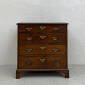 A Georgian mahogany chest of four long graduating drawers with shaped and pierced brass swan-neck