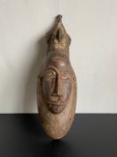 A West African carved hardwood ceremonial Mblo dance mask from the Baule tribespeople of the Ivory