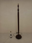 A vintage mahogany standard lamp with a reeded stem raised on a stepped circular plinth base on