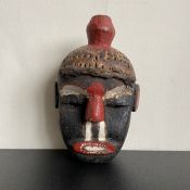 A 20th century West African carved Ibibio style polychrome tribal mask from Nigeria. L.30cm