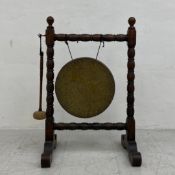 A C.1900 brass dinner gong and beater suspended from a square bobbin turned open oak frame with