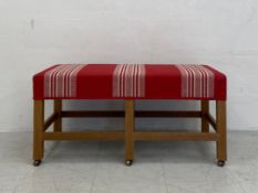 A contemporary ottoman or window seat having a rectangular striped calico upholstered stuff-over