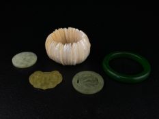 Five items to include a Chinese green jade bangle and three Bi discs along with a mother-of-pearl