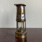 A Welsh brass mounted metal miners lamp with a cast maker's plaque. H.33.5cm (including handle)