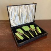 A silver hallmarked Art Deco vanity set to include four green guilloche brushes and a mirror in a