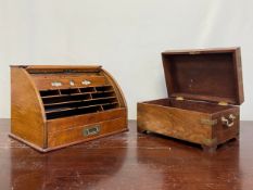 A C.1900 oak stationery box with a roll-top tambour lid opening to reveal a fitted interior along