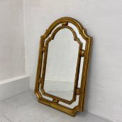 A 20th century giltwood wall mirror having a shaped plate in a moulded inner frame with a mirrored