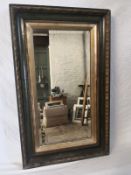 A late 19th century wall mirror having a rectangular hand bevelled plate in a heavy painted and